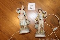 Full view of both bisque porcelain mini lamp figurines on wood surface, showing the detailed painting and lantern lights with power cords.