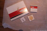 Three boxed items photographed from above showing large box for placemats and two smaller boxes likely for coasters and wall plate