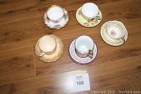 Top view of all 5 tea cups with saucers showing various floral and patterned designs