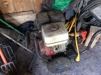 Full side view of pressure washer showing engine, frame, wheels and hose