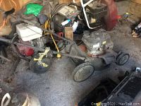 Overall view of lawnmower showing engine and deck, some additional equipment seen behind.