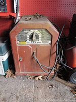 Front angled view of Lincoln Electric AC 225 welder showing cables and overall condition.