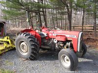 Side view of red Massey Ferguson 253 tractor showing overall condition, rear tires, engine area and roll bar