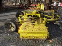 Front-side view of yellow steel deck, wheels, hitch assembly