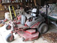 Front left angle showing overall mower, cutting deck and flat caster wheel