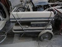 Side and top view of kerosene/diesel forced air heater showing dirt, cobwebs, and flat wheels.