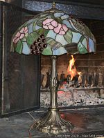 Full front view of lamp showing stained glass shade and metal base