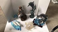 Wide shot showing entire dolphin sculpture art collection including various dolphin designs and materials