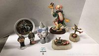 Wide shot showing all clown figurines on white surface for size and detail overview.