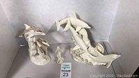 Four Lenox dolphin-themed porcelain figurines including a three-jump dolphin group, a decorated dolphin, a small mermaid, and a single jumping dolphin.