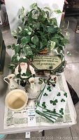 Overview of the Luck Of The Irish collection showing Belleek pottery, Irish-themed Santas, a plate with Irish blessing, shamrock towel, and a faux plant