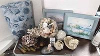 Photo of sea shell and snow baby lot including coastal paintings, shells, corals, fabric with sea motifs, and decorative items