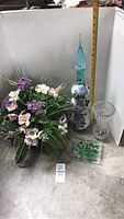 Lot items including tall blue and purple decorative vase, clear cut glass vase, floral arrangement, and glass tray.