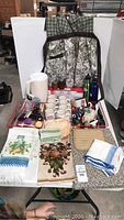 Overview of lot items including apron, mugs, bottles, cutting boards, towels, and kitchen tools