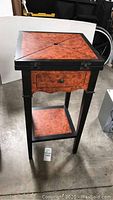 Full view of chess and checkers game table with closed top, showing the square top with wood-grain pattern and black frame, four legs, and lower shelf.