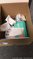 Cardboard box containing packaging materials, Kyrobak device box, and other items.