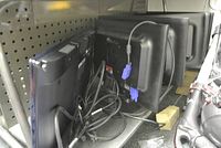 Six computer monitors on a metal shelf showing backs and cables, five HP and one Samsung without a base.