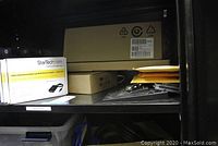 Two StarTech USB to VGA External Video Card adapters in branded boxes on shelf alongside brown box and envelopes