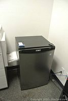 Closed view of the black Danby Designer mini fridge showing compact size and logo