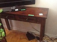 Front view of console table under TV, showing two drawers and metal stud decorations on the front.