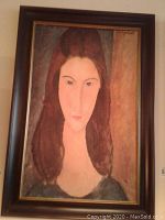 Framed print portrait of a woman with long brown hair in earth tone colors.