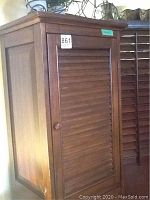 Front view of wooden cabinet with louvered doors