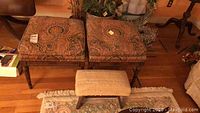 Front view of two large square ottomans with patterned upholstery and a smaller ribbed fabric ottoman in front, showing overall condition and style.