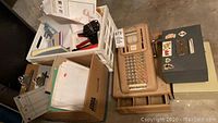 Wide view showing vintage Victor cash register, metal boxes, clipboards, assorted paper, stapler, and staple gun.