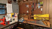 Wide view showing various hand tools on pegboard and drawers under workbench including Stanley mitre box and hand saws