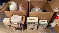 Boxes and loose items including iced coffee maker, Cuisinart appliances, boxed items and food storage containers stacked in cardboard boxes and on floor.