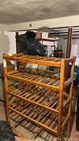 Full frontal view of four-shelf wooden rack on wheels in garage setting