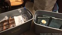 Two bins containing all items: glassware, metal wall decor, and ceramic pieces