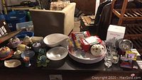 Wide view showing various lusterware pottery, bowls, red lidded containers, and assorted decorative items with San Francisco snow globes and souvenirs