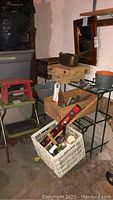 Image showing metal plant stand with rust, folding metal stool with visible wear, and 16x20 wall mirror with wooden frame.
