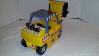 Yellow plastic Tonka motorized forklift toy viewed from front showing controls and Decals.