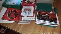 Two stacks of Christmas cards laid out on a table featuring various holiday designs including poinsettias and snowmen.
