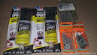 Photo showing two epoxy resin bottles, packs of flat washers, cotter pins, and metal cutters.