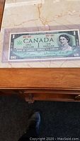 Photo of commemorative Canadian one dollar bill 1867-1967 featuring Queen Elizabeth II and signatures.