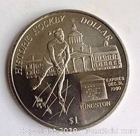 Front side of a commemorative coin showing hockey player, building, dollar value, expiration date and location.