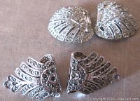 Front view of two pairs of silver-tone Art Deco style clips with clear rhinestones and marcasite stones arranged in fan patterns