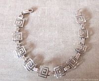 Vintage sterling silver Greek key link bracelet fully extended, showing design detail on all links and lobster clasp