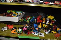 Shelf displaying assorted toy vehicles including various cars and trucks