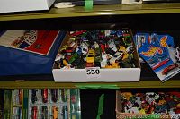 White tray filled with numerous loose toy vehicles including various cars and trucks and a few still-in-package Hot Wheels cars