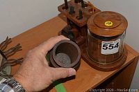Wood pipe stand holding six pipes, wooden tobacco jar with wood lid, and part of a meerschaum pipe