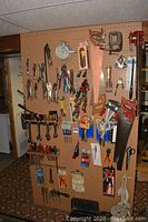 Full pegboard view showing arrangement of wrenches, screwdrivers, pliers, saws, clamps and bits
