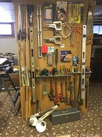 Full pegboard display of tools with toolbox and bench lights