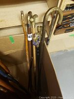 Seven walking sticks in box showing varied handles