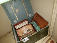 Opened large green wooden box containing smaller wooden boxes filled with various rocks and minerals.