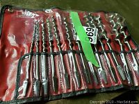 Overall view of drill bits rolled out in pouch displayed on surface.