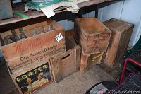 Overall view of four wooden crates and Coca-Cola bottles grouped on floor